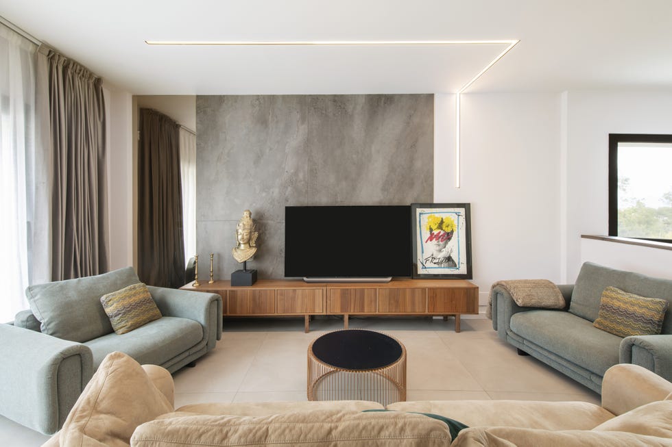salón moderno con tres sofás y mueble tv de madera
