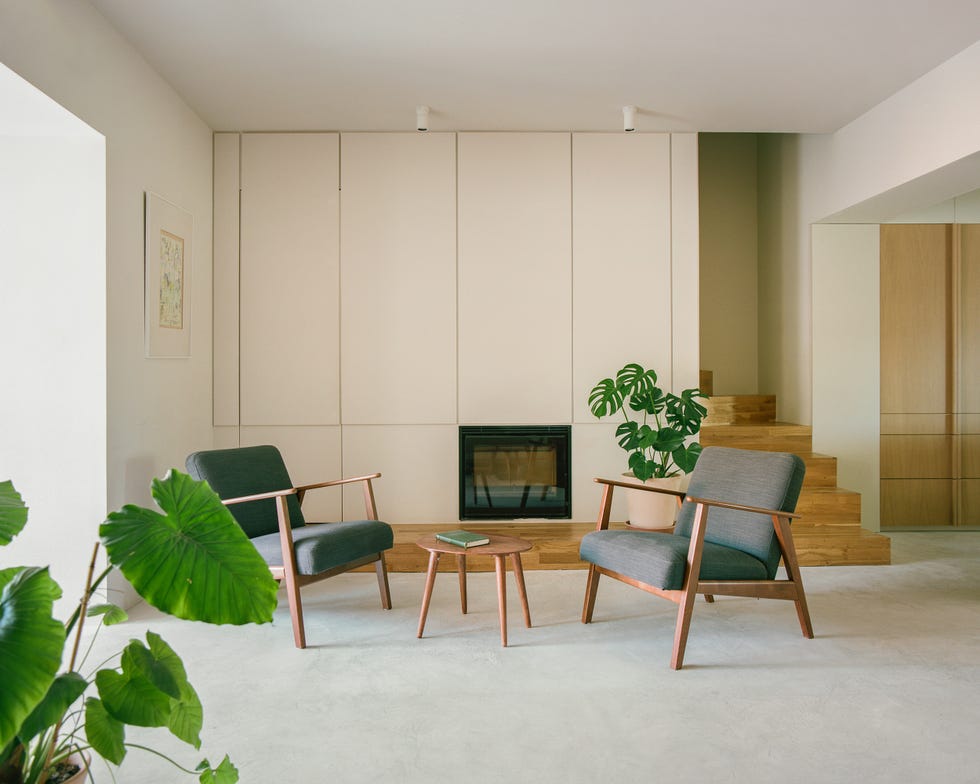salón moderno con dos butacas grises y mesa auxiliar de madera redonda