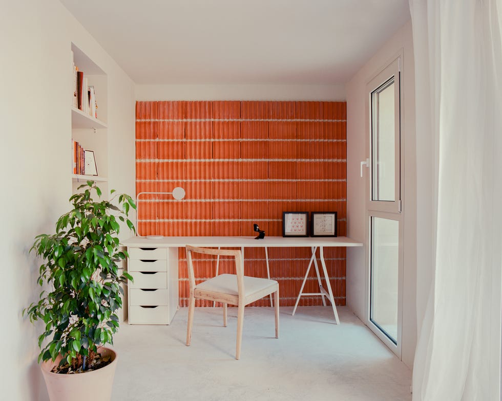 despacho con mesa de escritorio blanca y pared de ladrillo visto