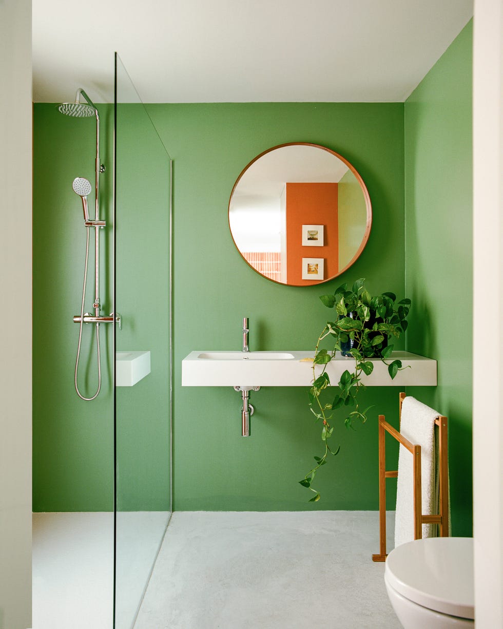 baño pintado en verde con ducha y lavabo volado