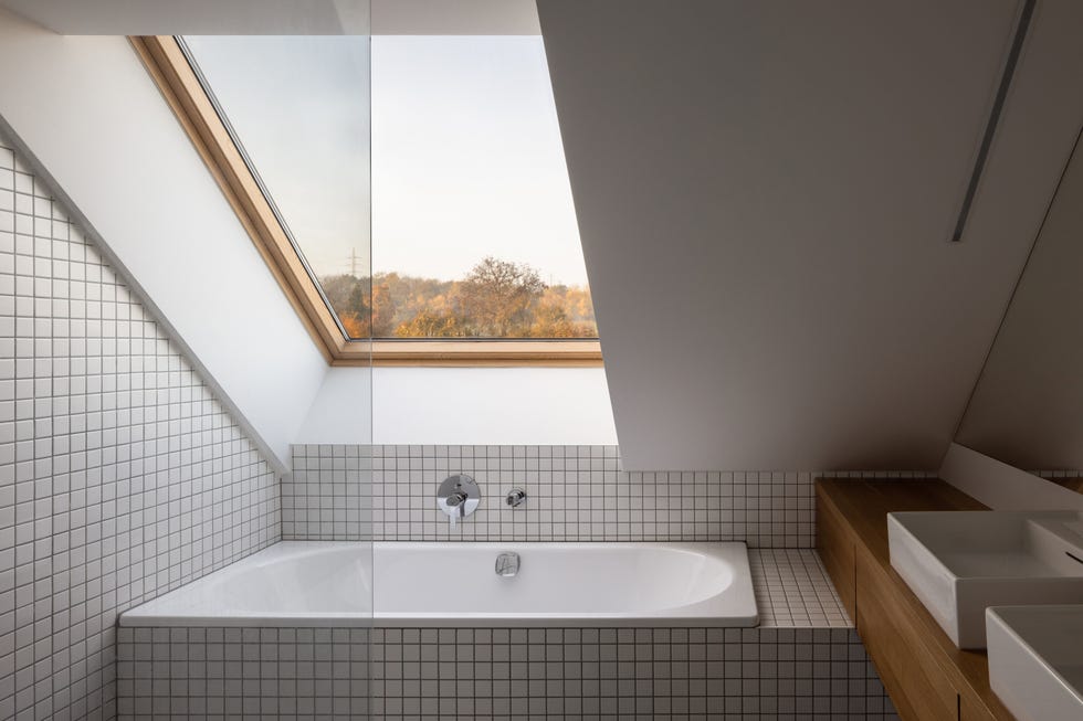 baño abuhardillado con bañera y azulejos cuadrados blancos