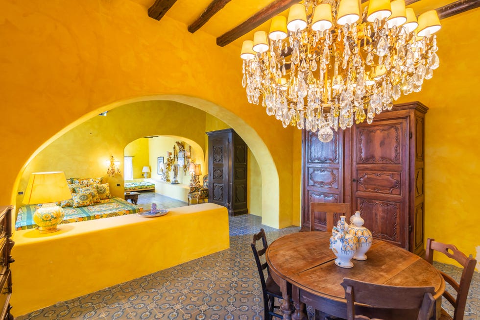 comedor abierto al salón con paredes de piedra y muebles antiguos