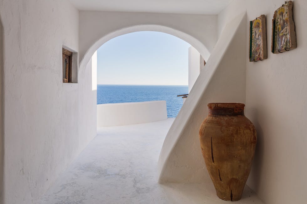 recibidor de estilo mediterráneo en piedra blanca con vistas al mar