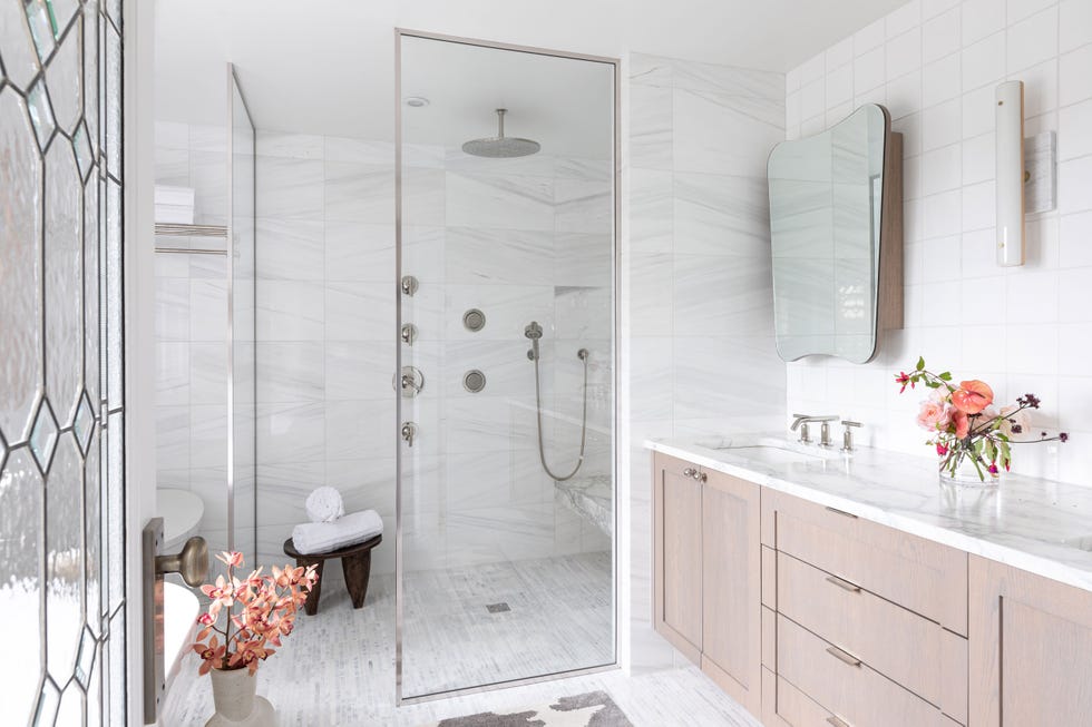 baño con ducha y bañera y revestimientos de mármol