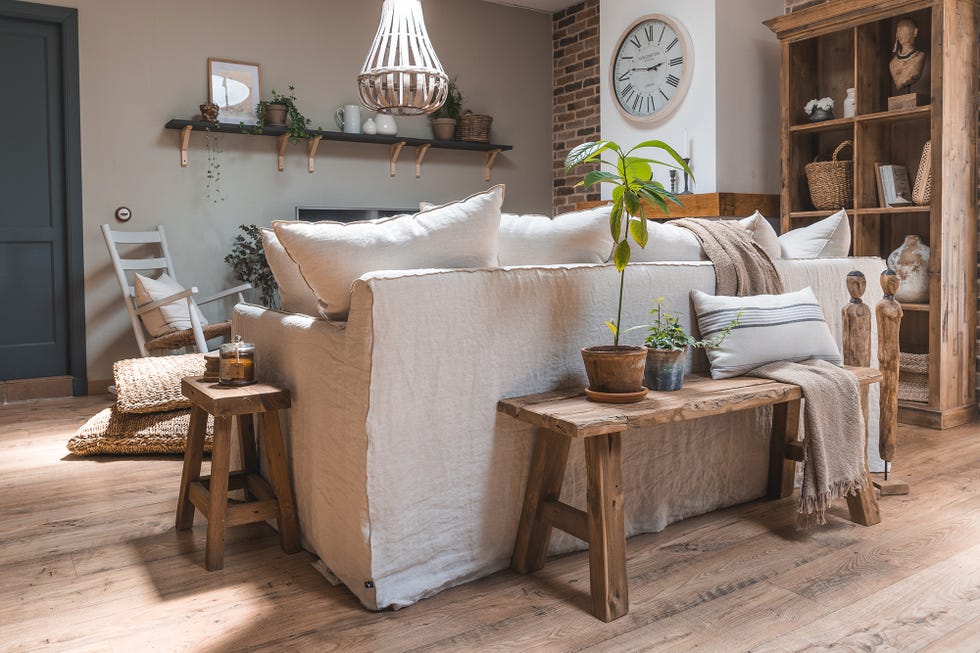 salón de estilo rústico con sofá de lino blanco y banco de madera al natural