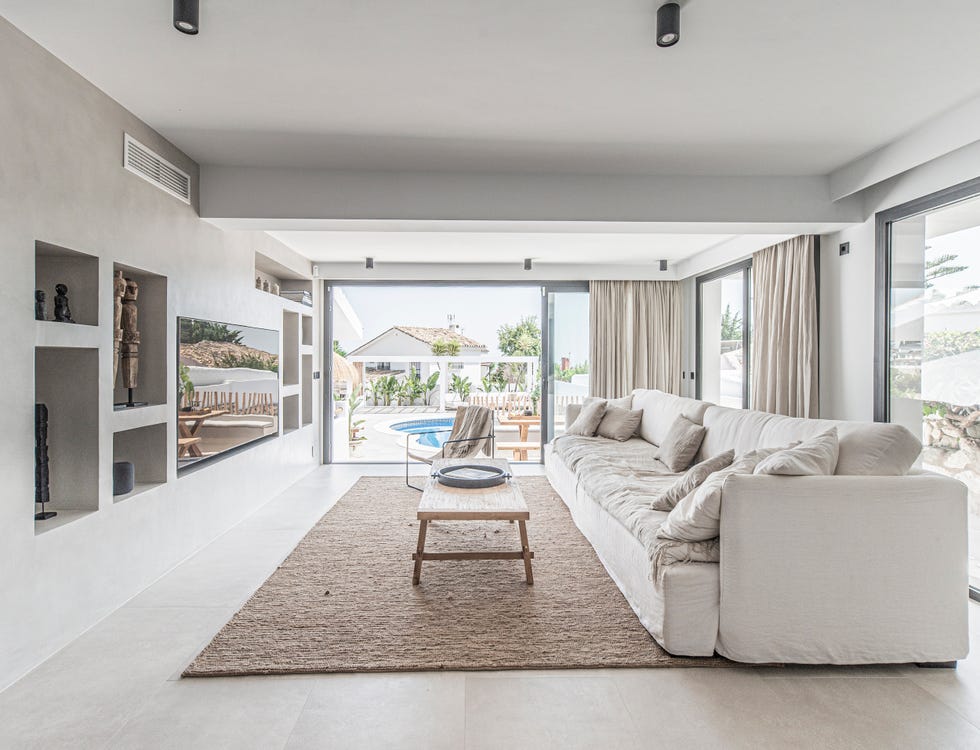 salón escandinavo y boho con sofá de lino blanco y paredes de microcemento