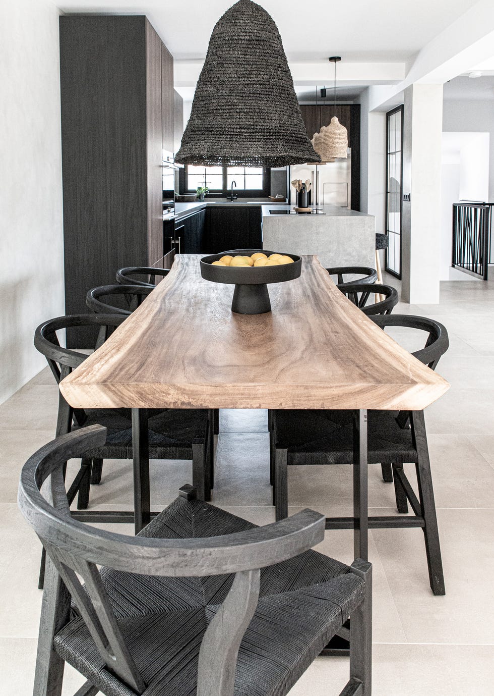 comedor escandinavo y boho con mesa de madera y sillas de madera negra con asientos de fibras