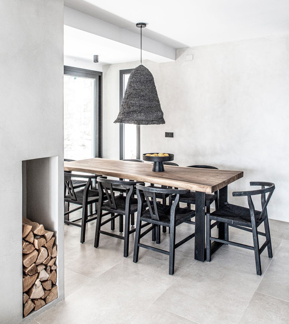 comedor escandinavo y boho con mesa de madera y sillas de madera negra con asientos de fibras
