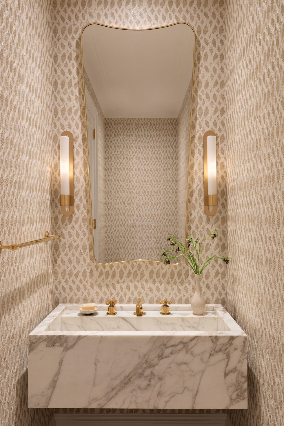baño con mueble de mármol y papel pintado con motivos geométricos