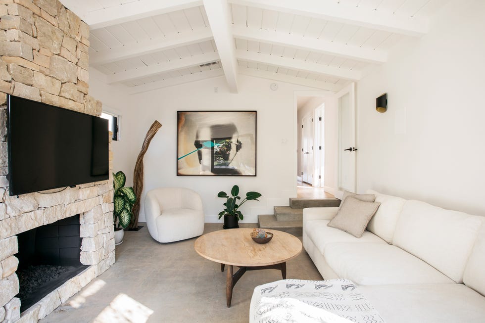 salón con chimenea de piedra decorado en tonos neutros