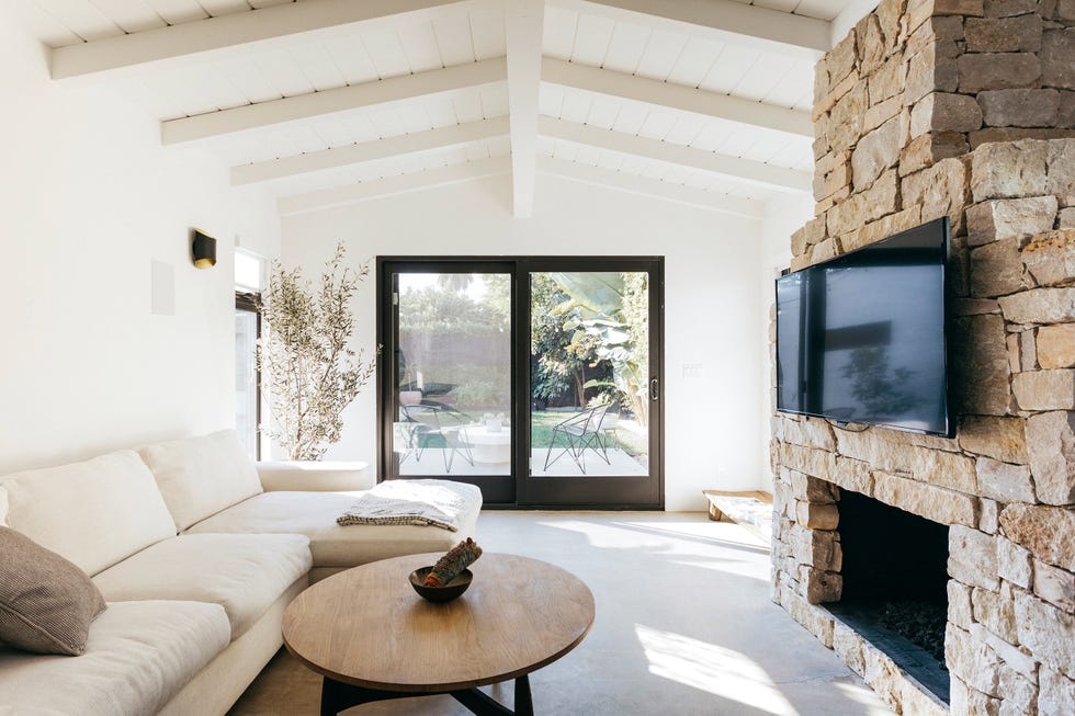 salón con chimenea de piedra decorado en tonos neutros