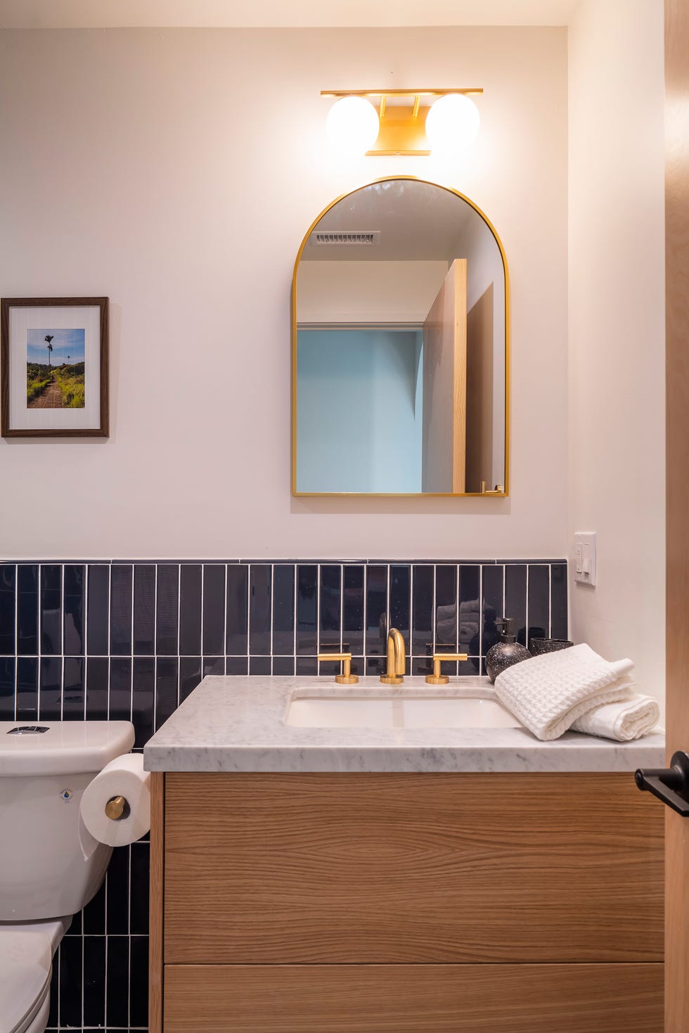 baño con mueble de madera y azulejos azules