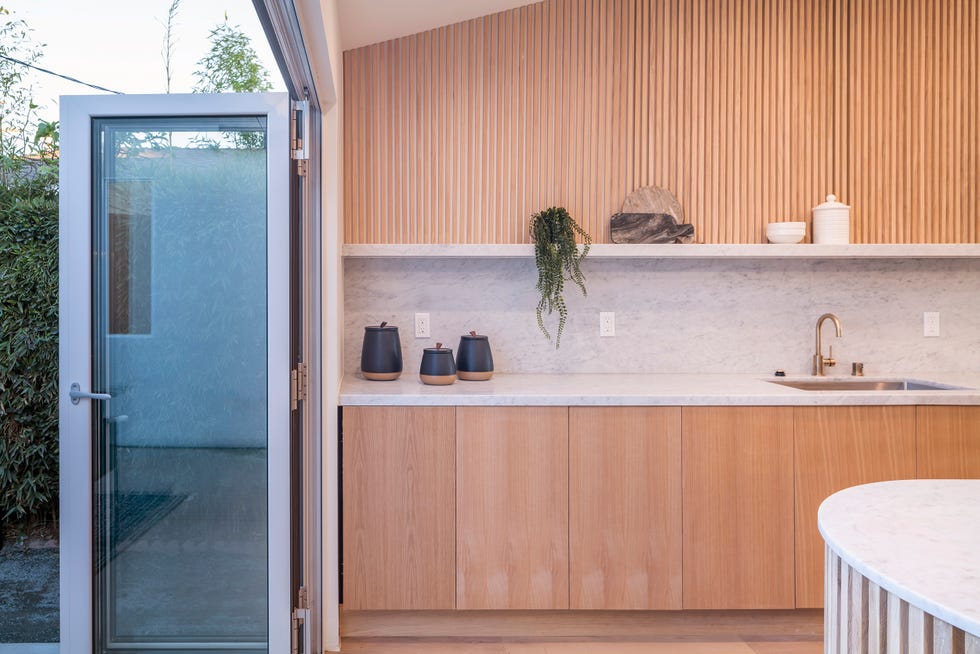 cocina abierta con muebles de madera y encimera de mármol