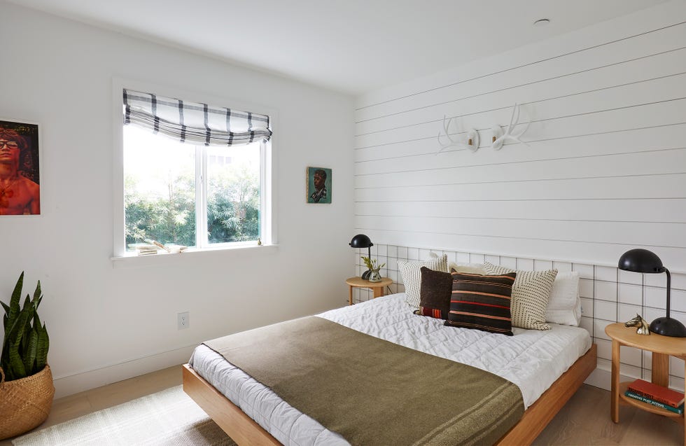 dormitorio de estilo bohemio decorado en blanco con mobiliario de madera