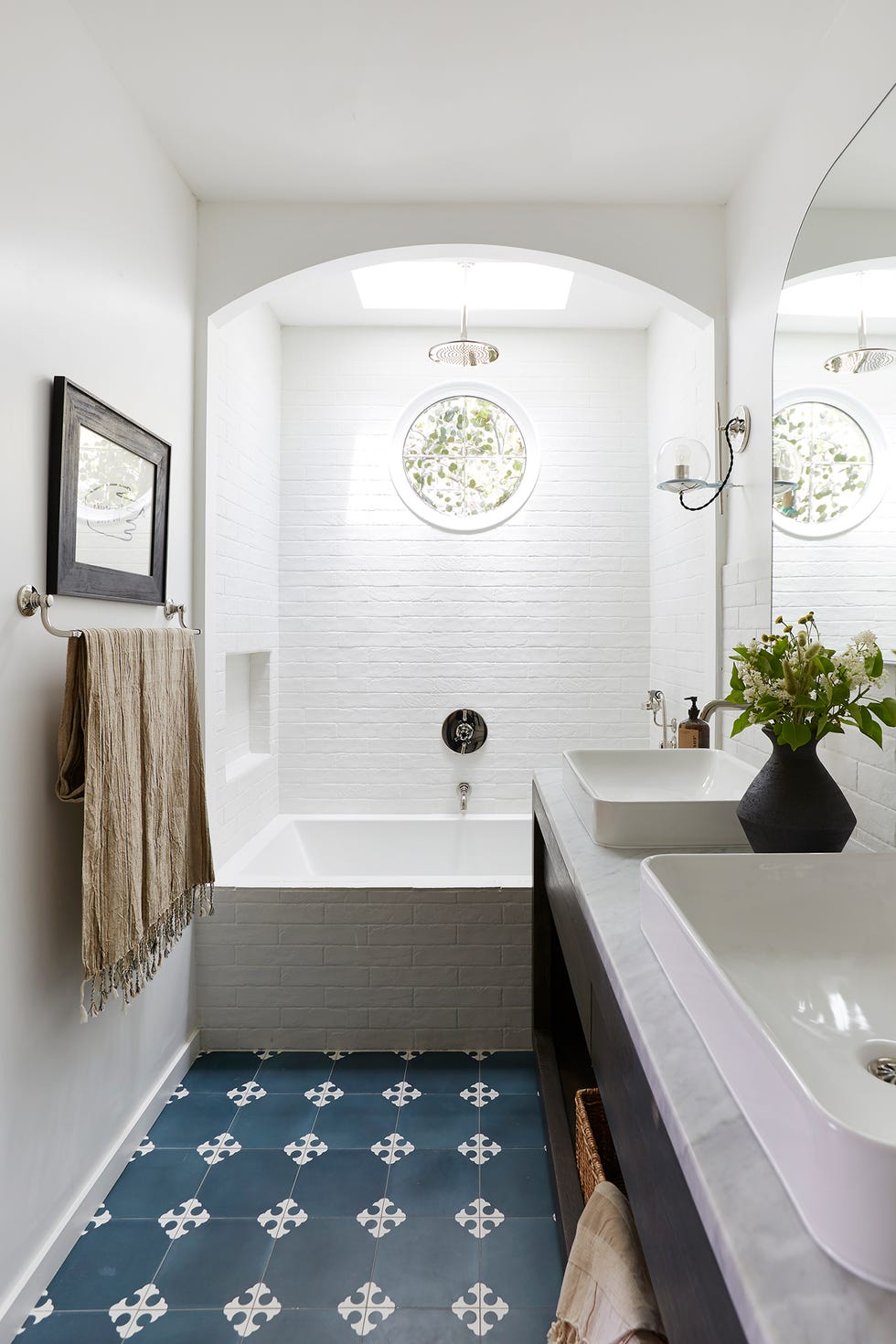 baño blanco con bañera y suelo de baldosas azul marino