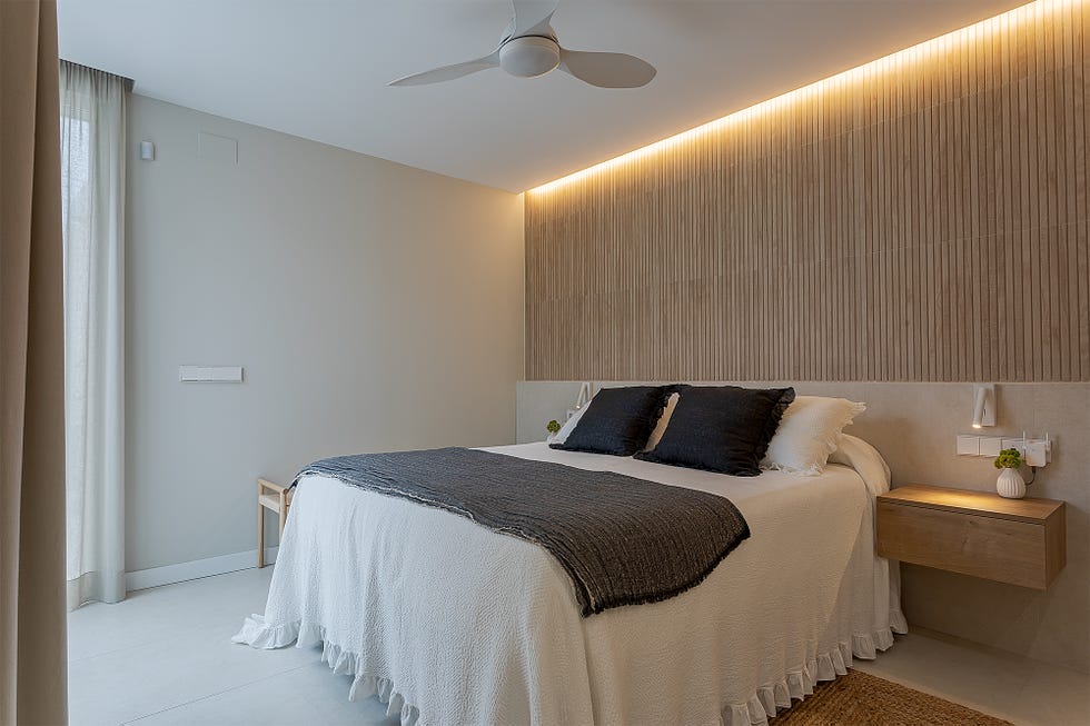 dormitorio con pared del cabecero de lamas de madera