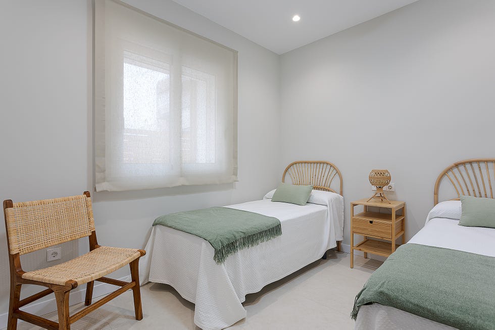 habitación con dos camas individuales con cabeceros de ratán