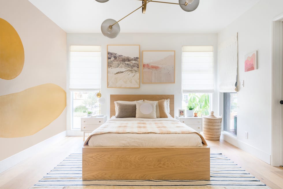 dormitorio de estilo boho con cama de madera y mural abstracto
