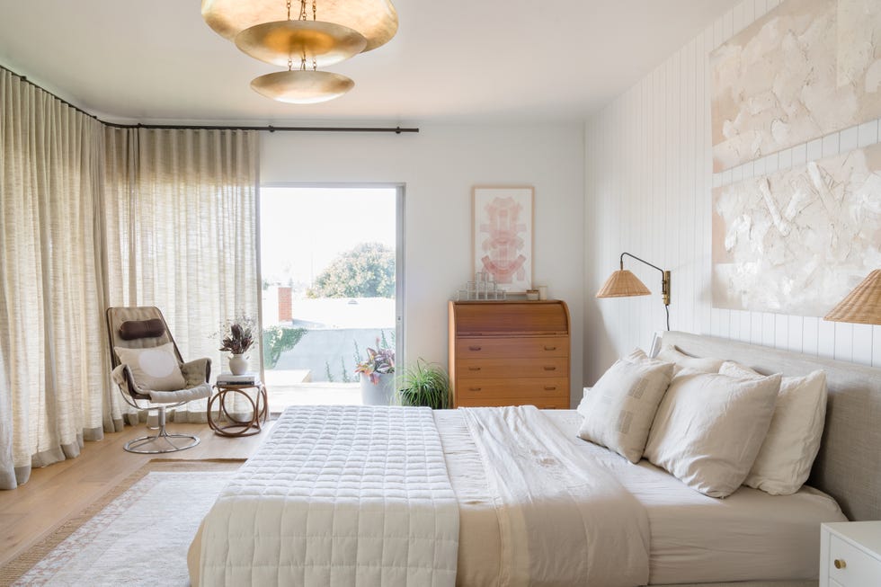 dormitorio decorado en beige con pared de lamas de madera en el cabecero