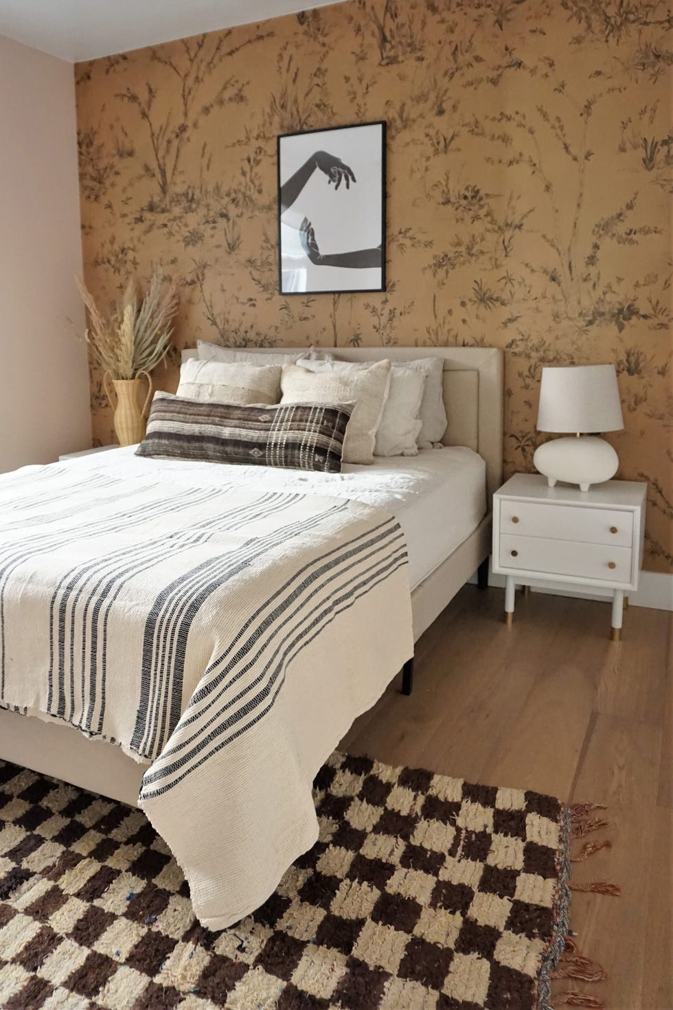 dormitorio de estilo boho con papel pintado floral en el cabecero