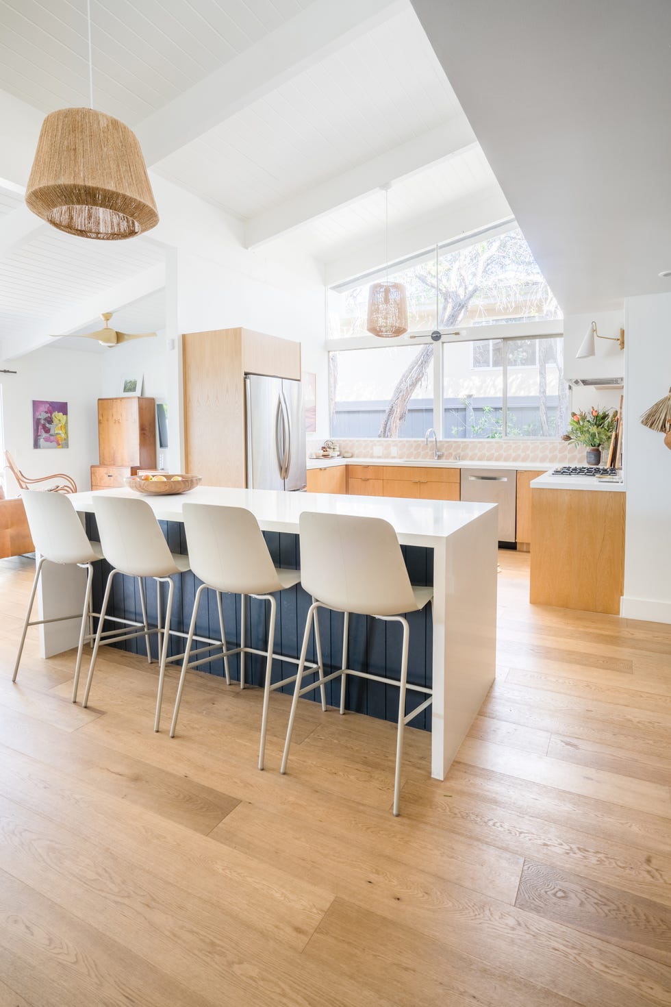 cocina abierta con isla central y armarios con puertas de madera