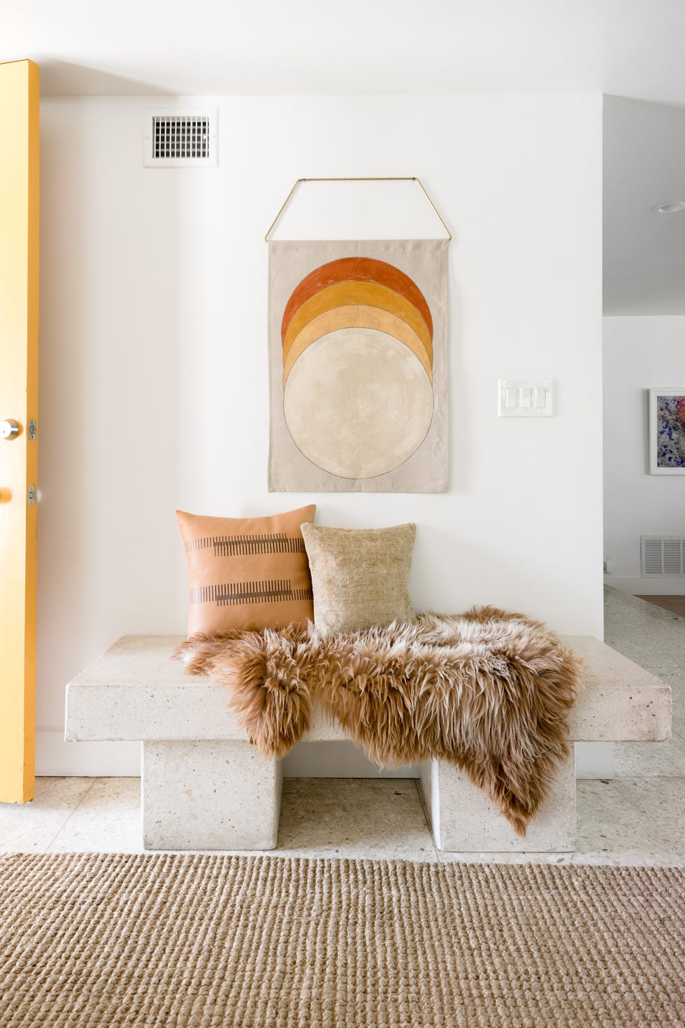recibidor de estilo boho con banco de piedra