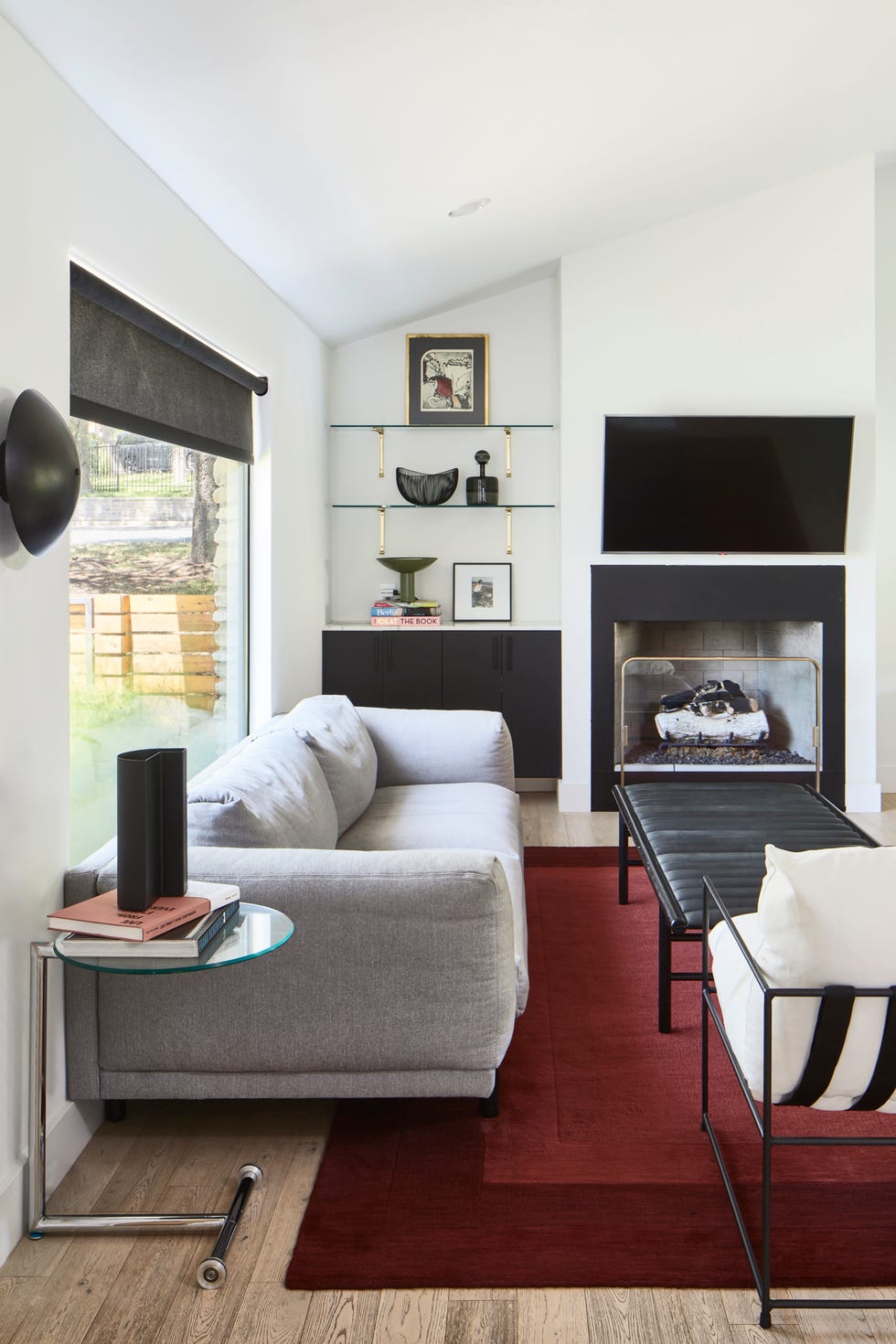 salón de estilo mid century con sofá gris y chimenea