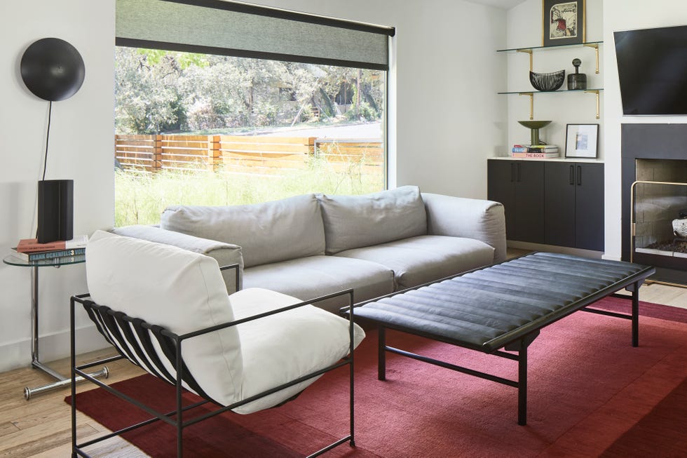 salón de estilo mid century con sofá gris y chimenea