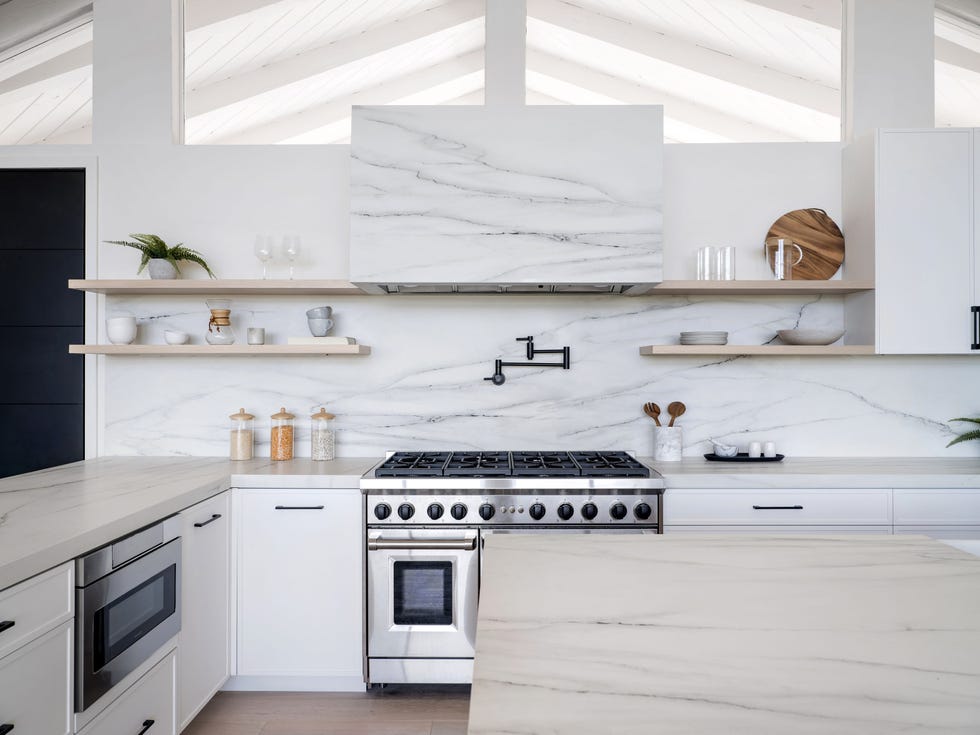 cocina blanca con encimera y revestimiento de mármol