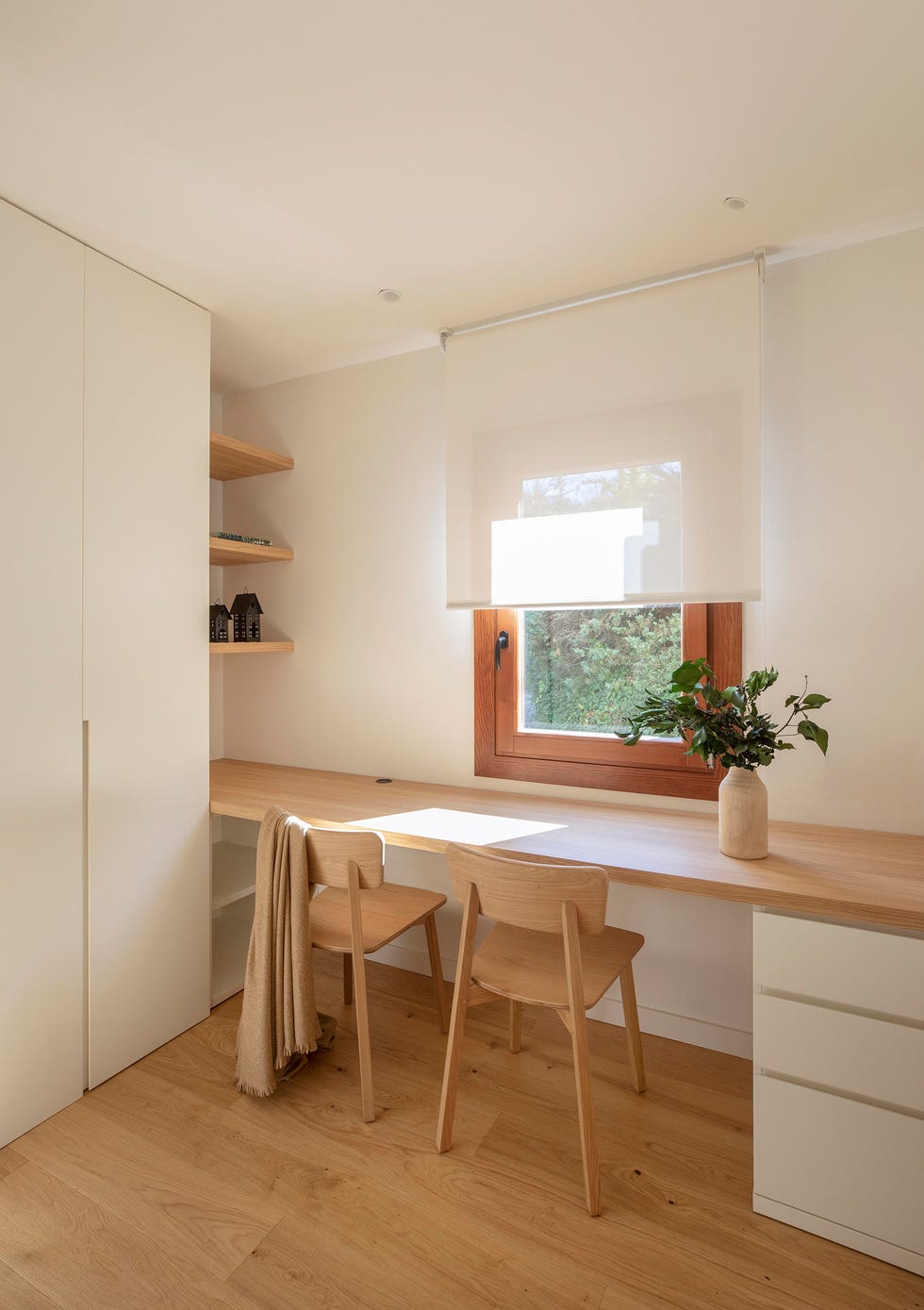 escritorio con balda de madera, cajonera blanca y sillas de madera