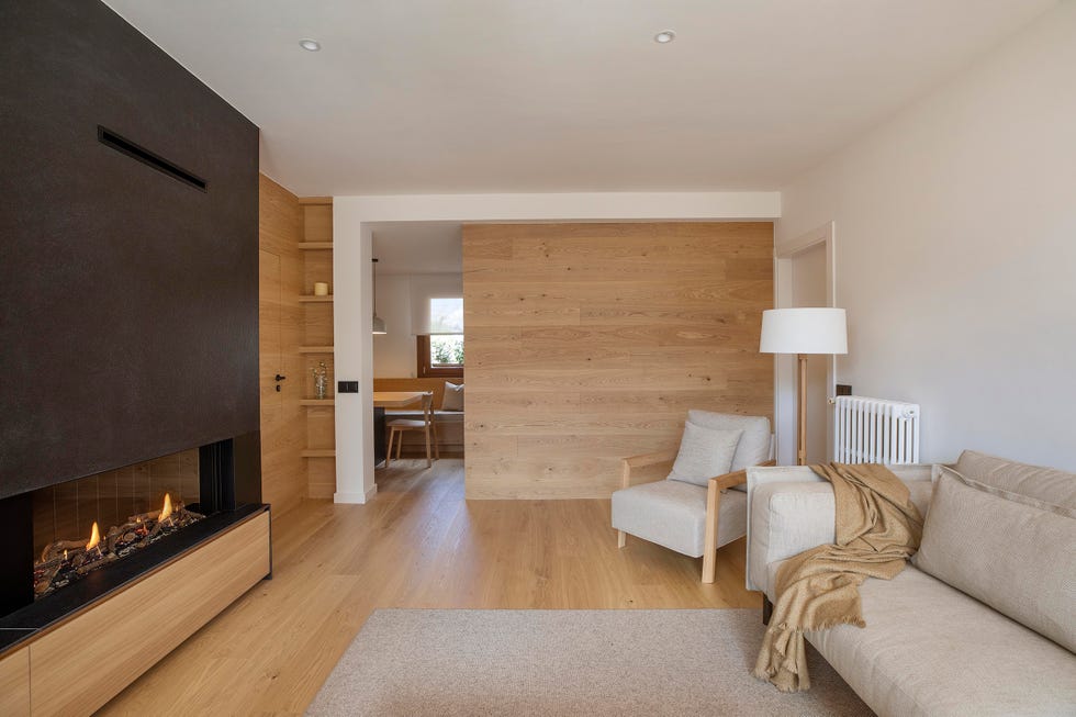 salón con chimenea, sofá y butaca beige