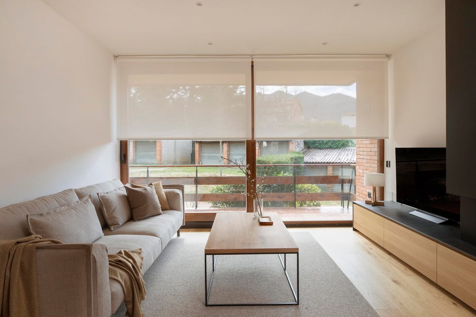 salón con sofá beige, mesa de centro de madera y mueble de tv a juego