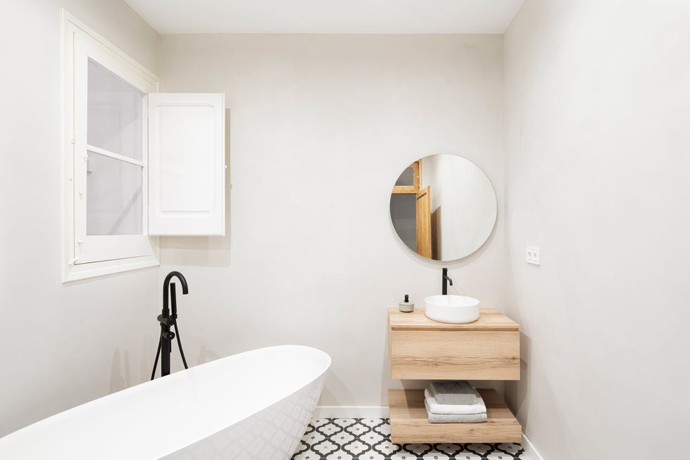 baño con mueble de madera volado y bañera exenta