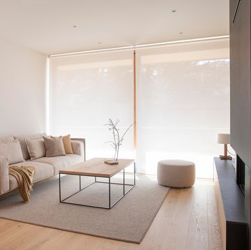 salón con sofá beige, puf y mesa de centro de madera