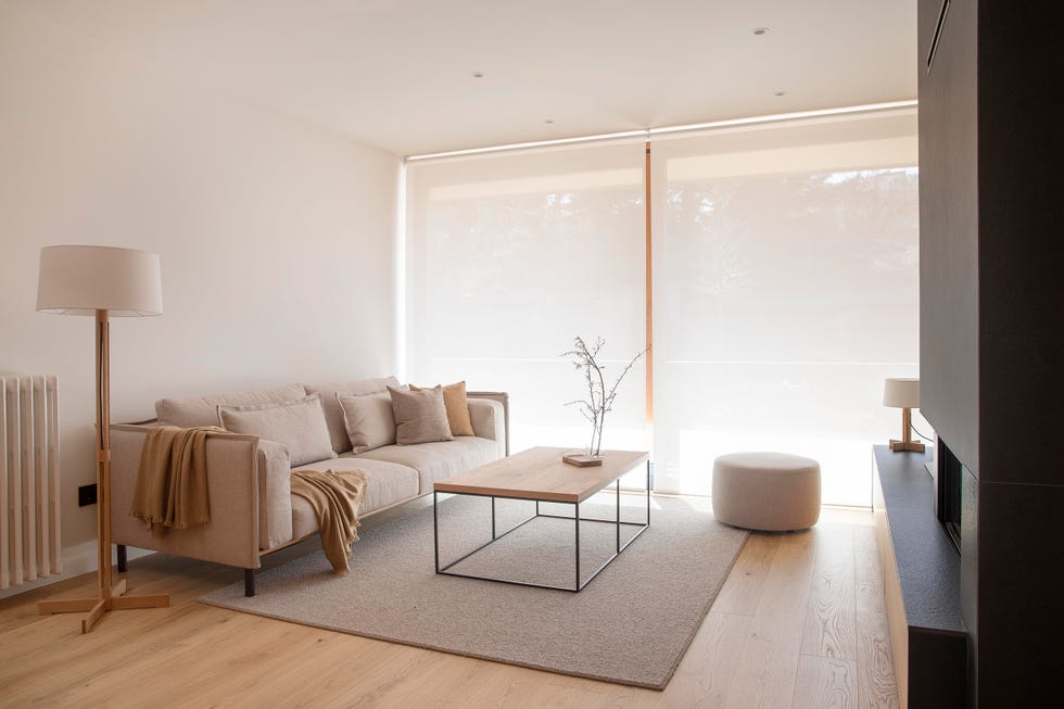 salón con sofá beige, puf y mesa de centro de madera