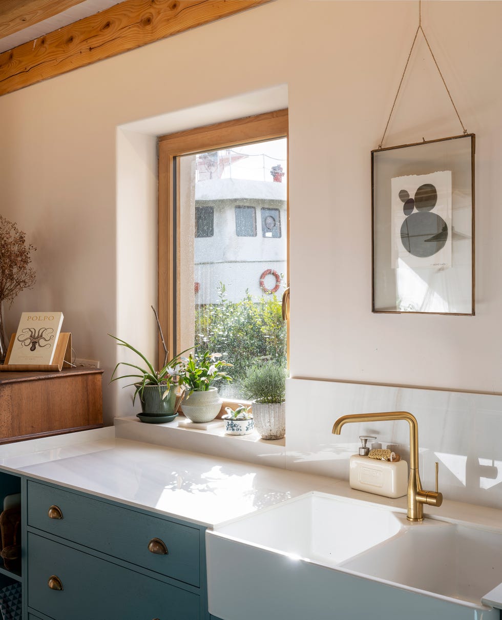 cocina con isla de mármol y fregadero rústico con grifo dorado