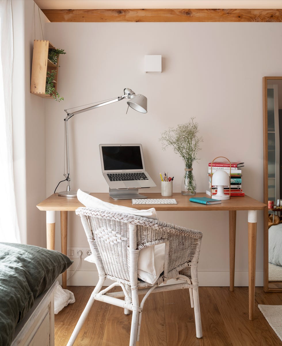 escritorio de madera y silla de mimbre blanca