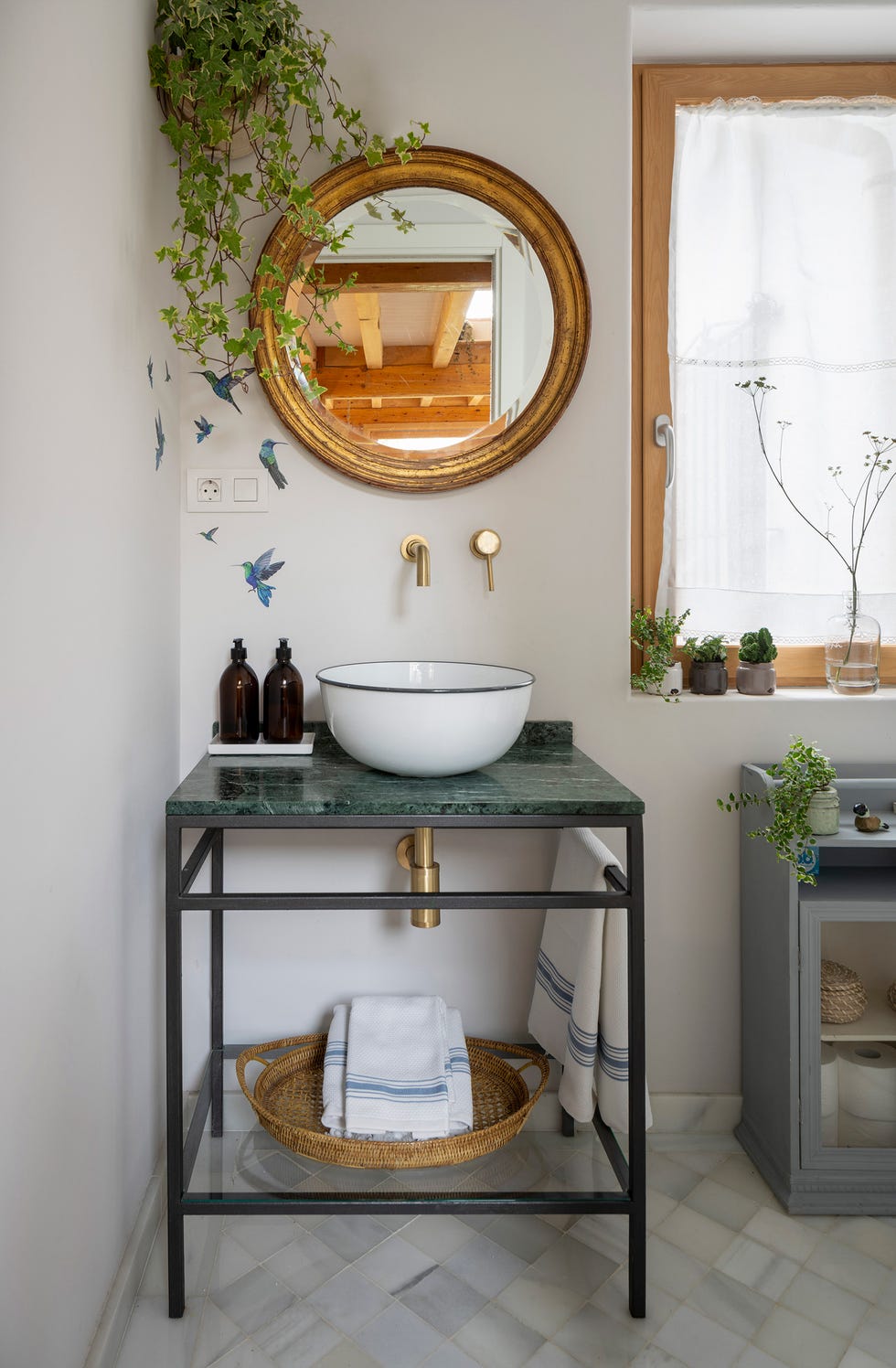 baño rústico con mueble de mármol y espejo redondo dorado