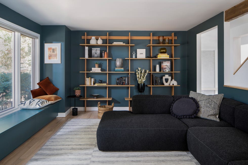 salón de diseño contemporáneo con paredes azules y sofá en l tapizado en negro