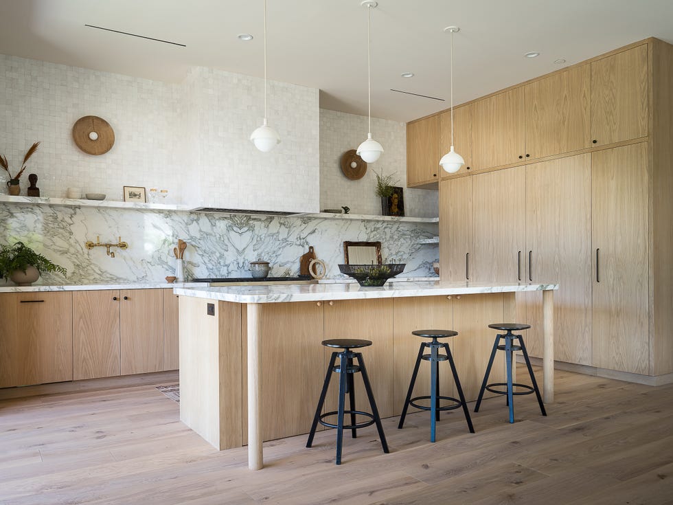 cocina con isla central de madera con diseño moderno y abierta a la terraza