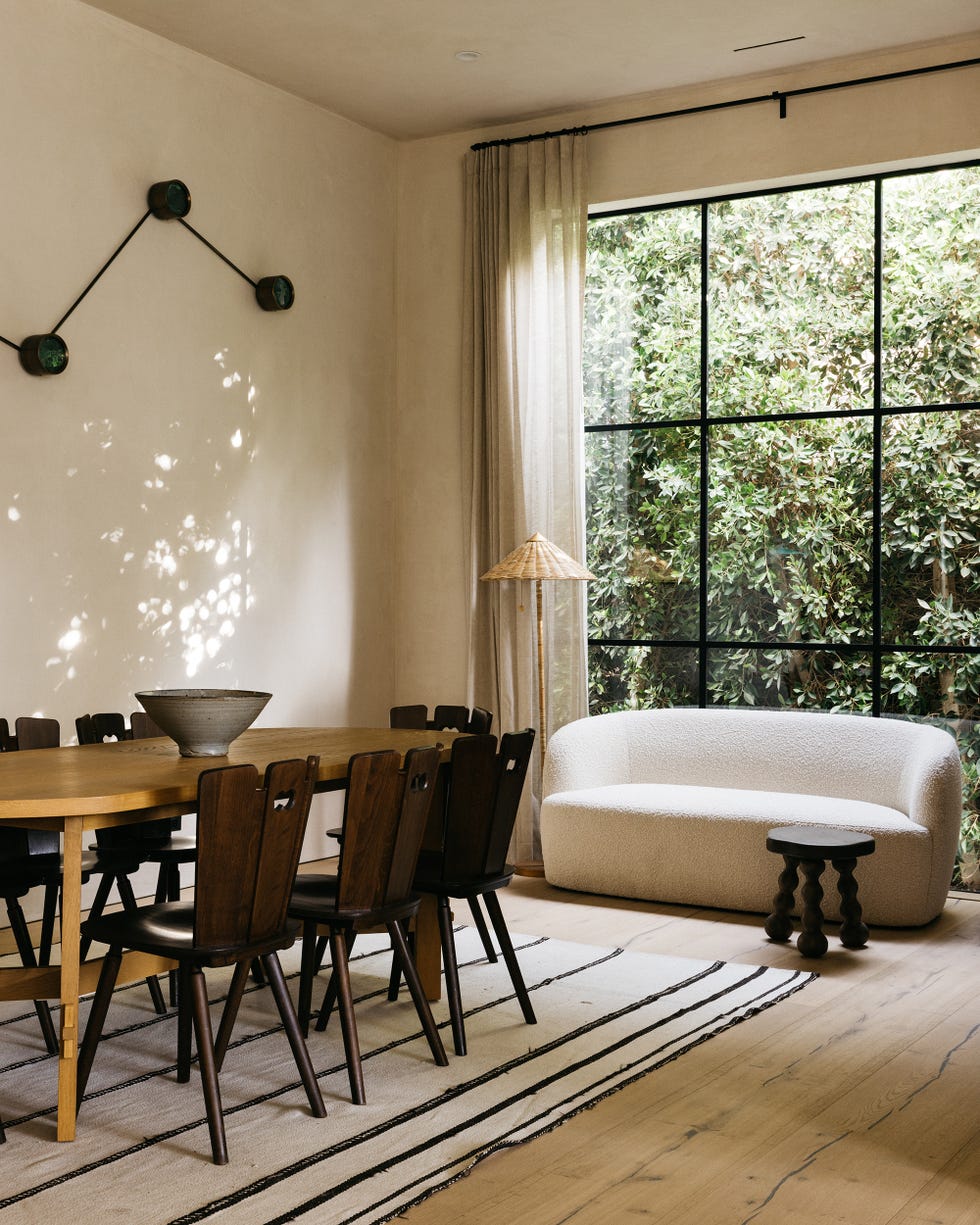 comedor con mesa y sillas de madera y sofá con tapizado bouclé