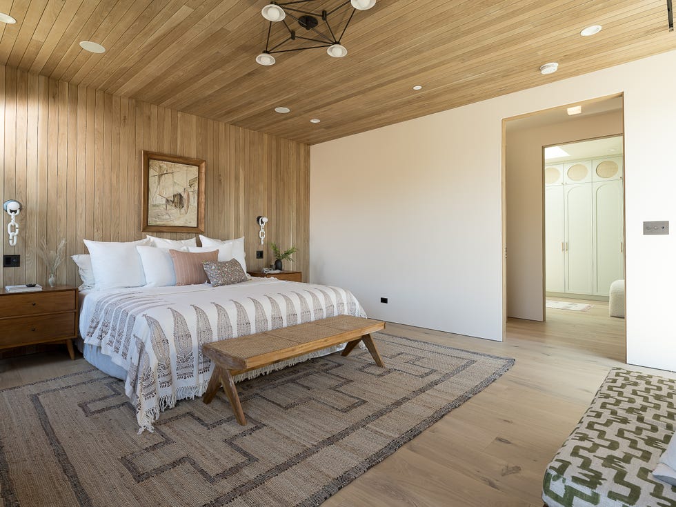 dormitorio con vestidor con el techo y la pared revestidos con lamas de madera