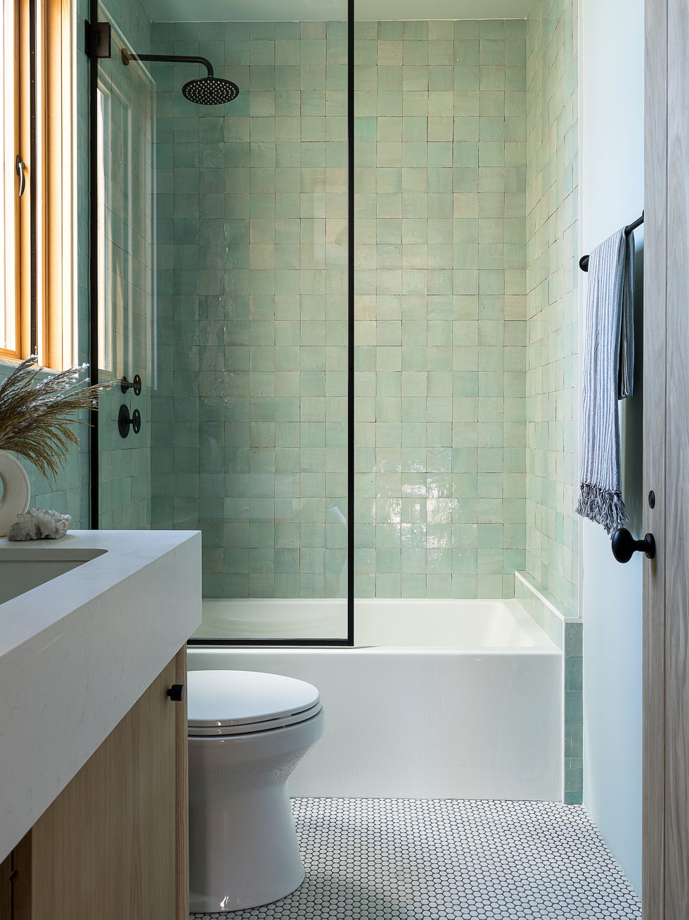 baño con bañera y ducha con paredes de azulejos verdes cuadrados