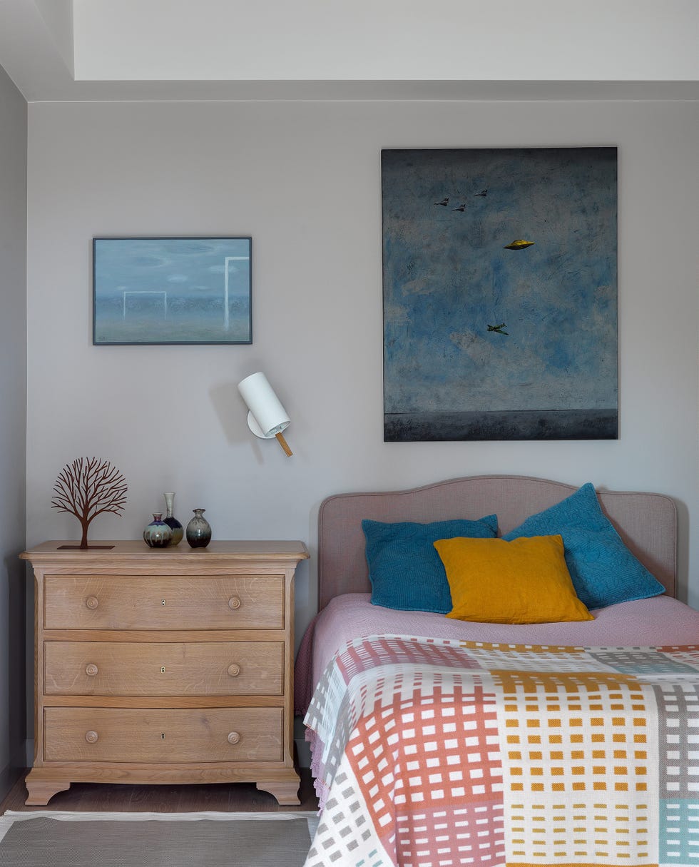 dormitorio de estilo clásico y contemporáneo con cabecero tapizado en color rosa y mesilla de madera