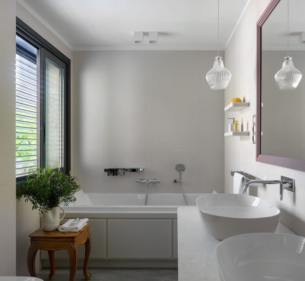 baño moderno diseñado en blanco con dos lavabos y bañera