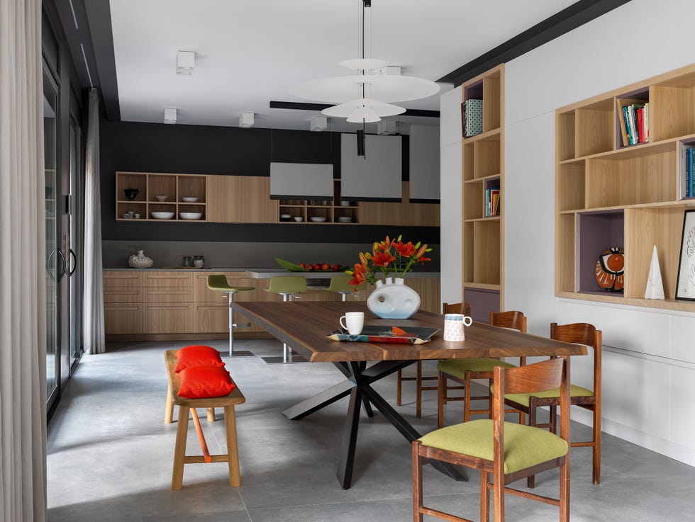 comedor de diseño contemporáneo abierto a la cocina junto a una estantería de obra