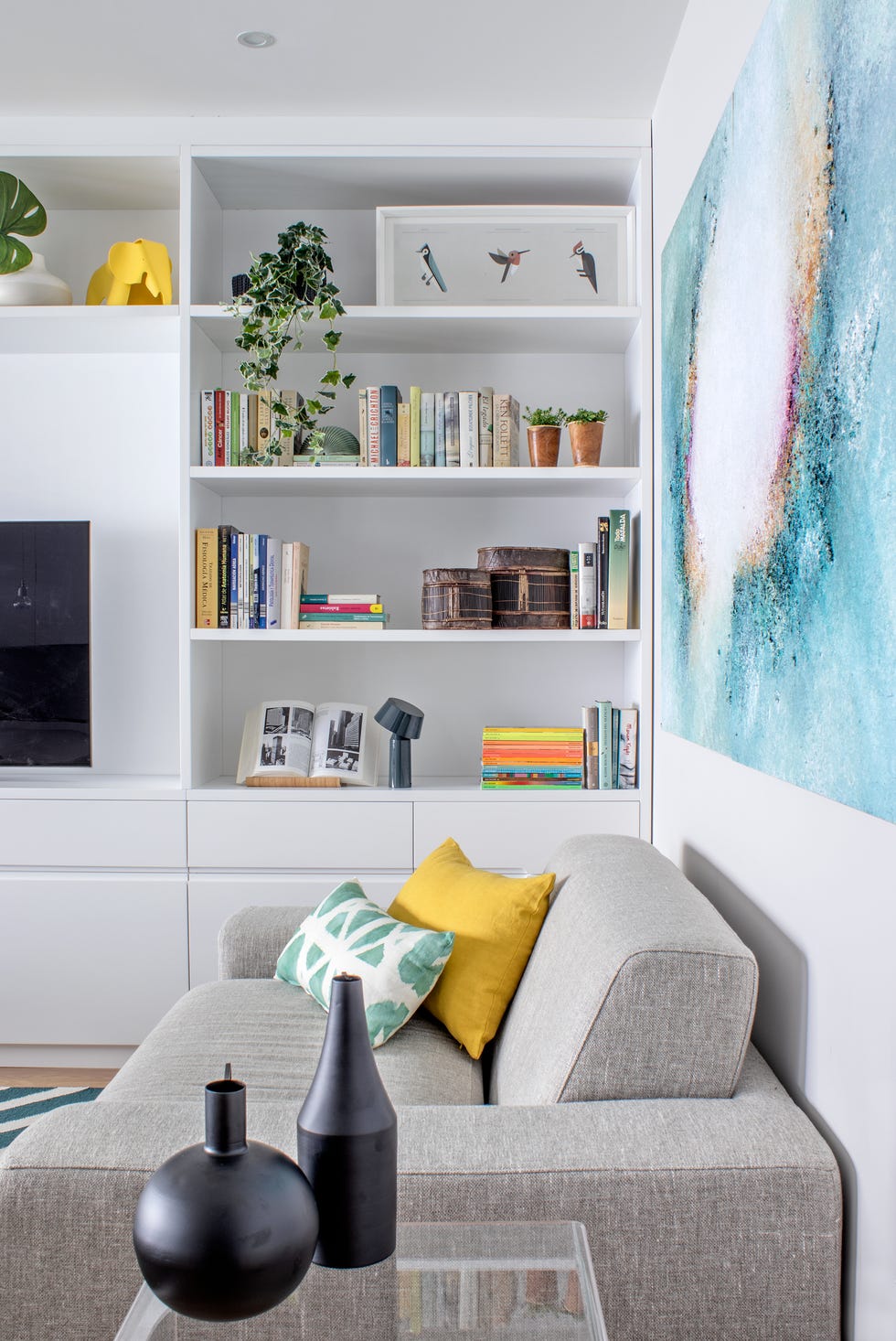 salón moderno con sofá gris y estantería blanca moderna
