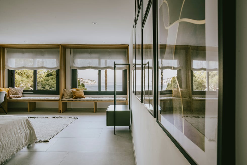 dormitorio con bancos bajo las ventanas