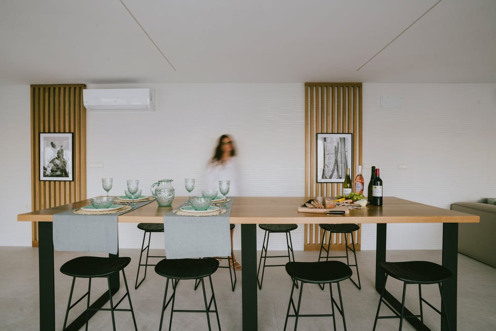 comedor con mesa de madera alargada y taburetes negros