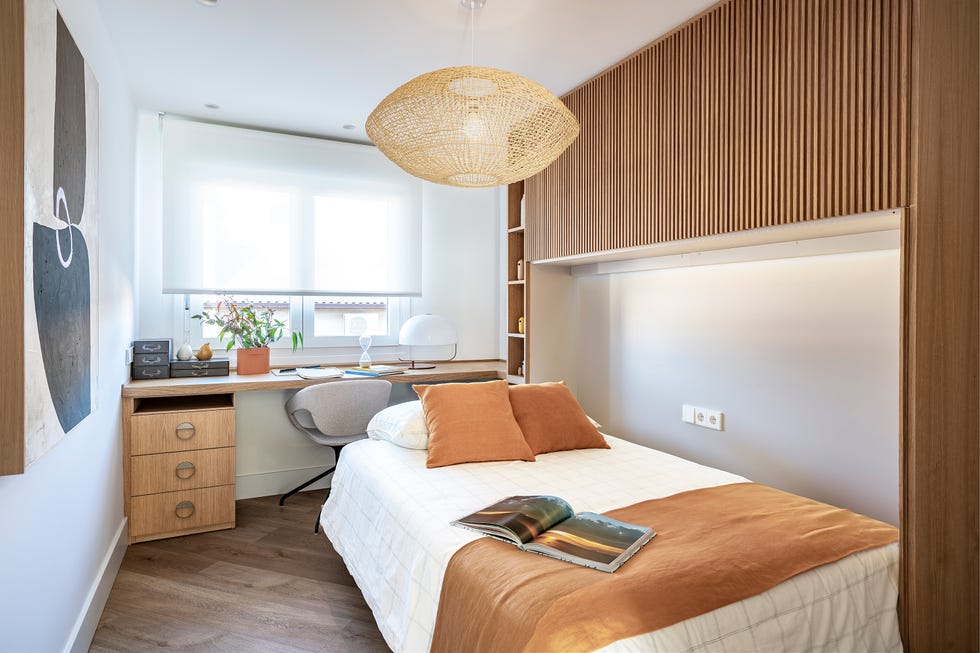 habitación con escritorio y cama abatible escondida en revestimiento de palillería